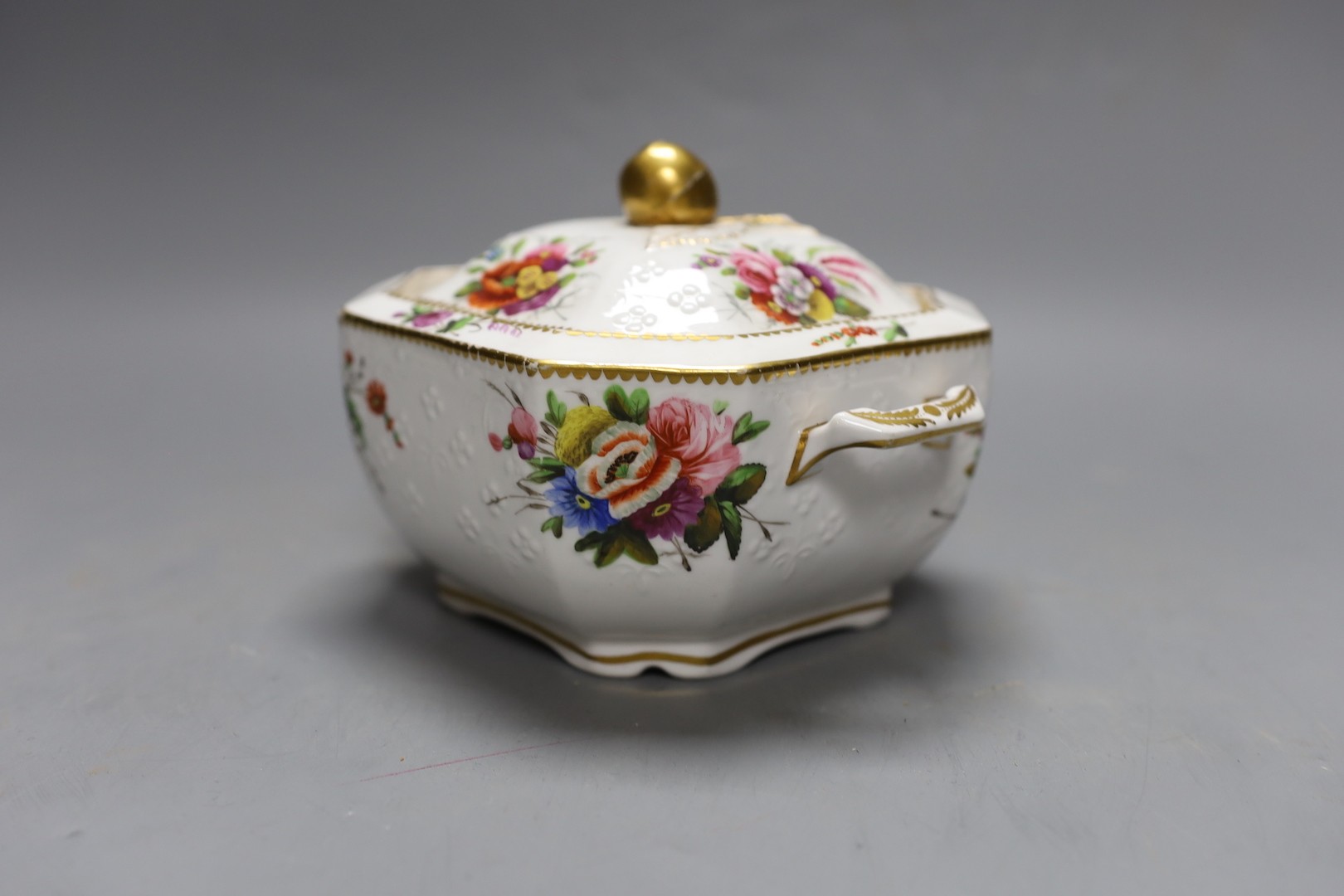 A Spode sugar box and cover of moulded form painted with flowers having a fruit finial, marked Spode 2527. 16cm